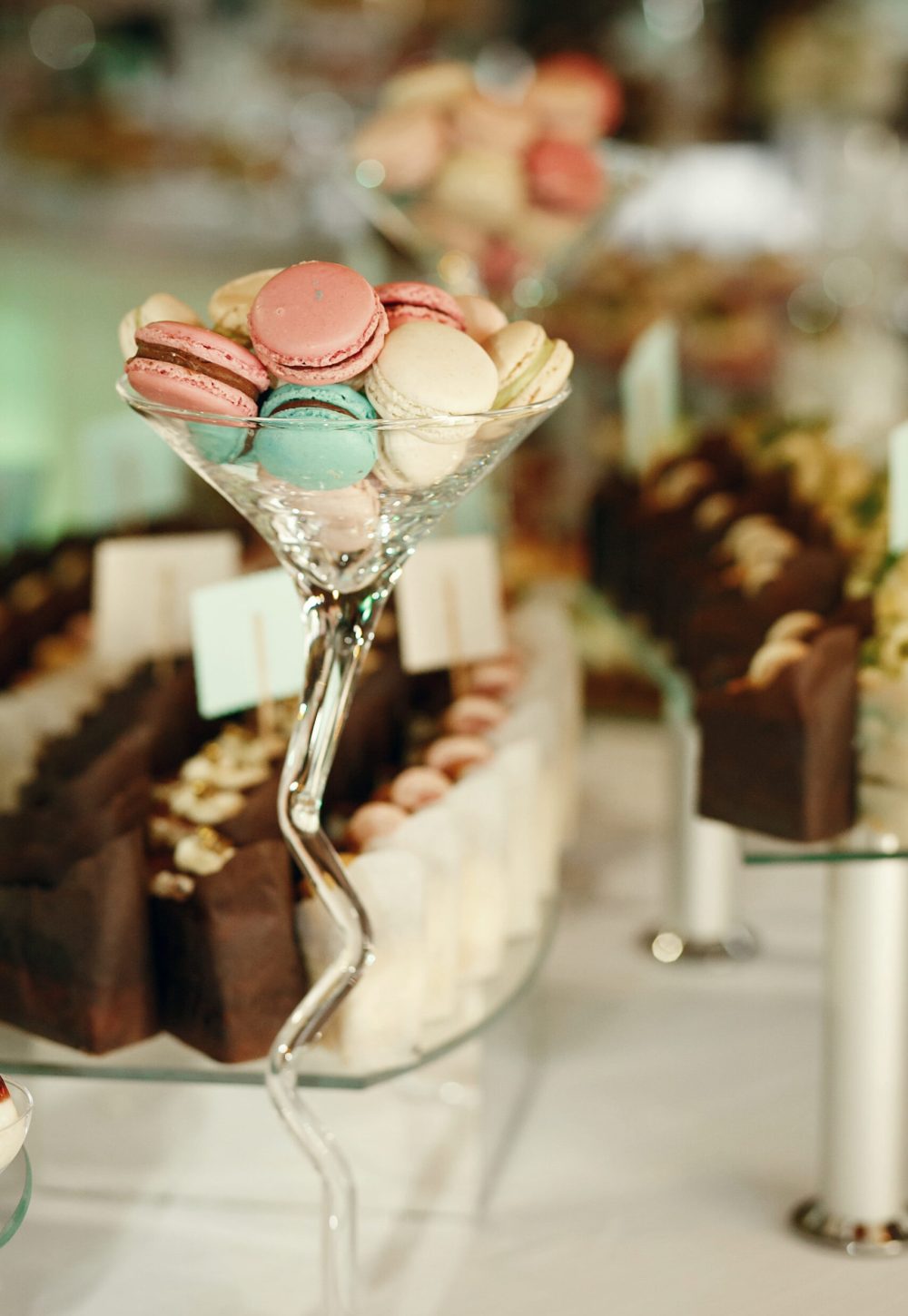 Large cocktail glass with macaroons stands on the dinner table